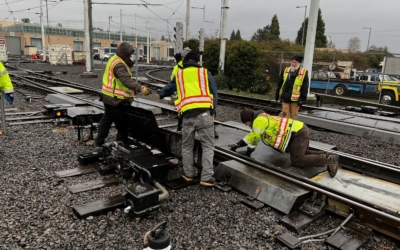 Workers inspecting light rail switch